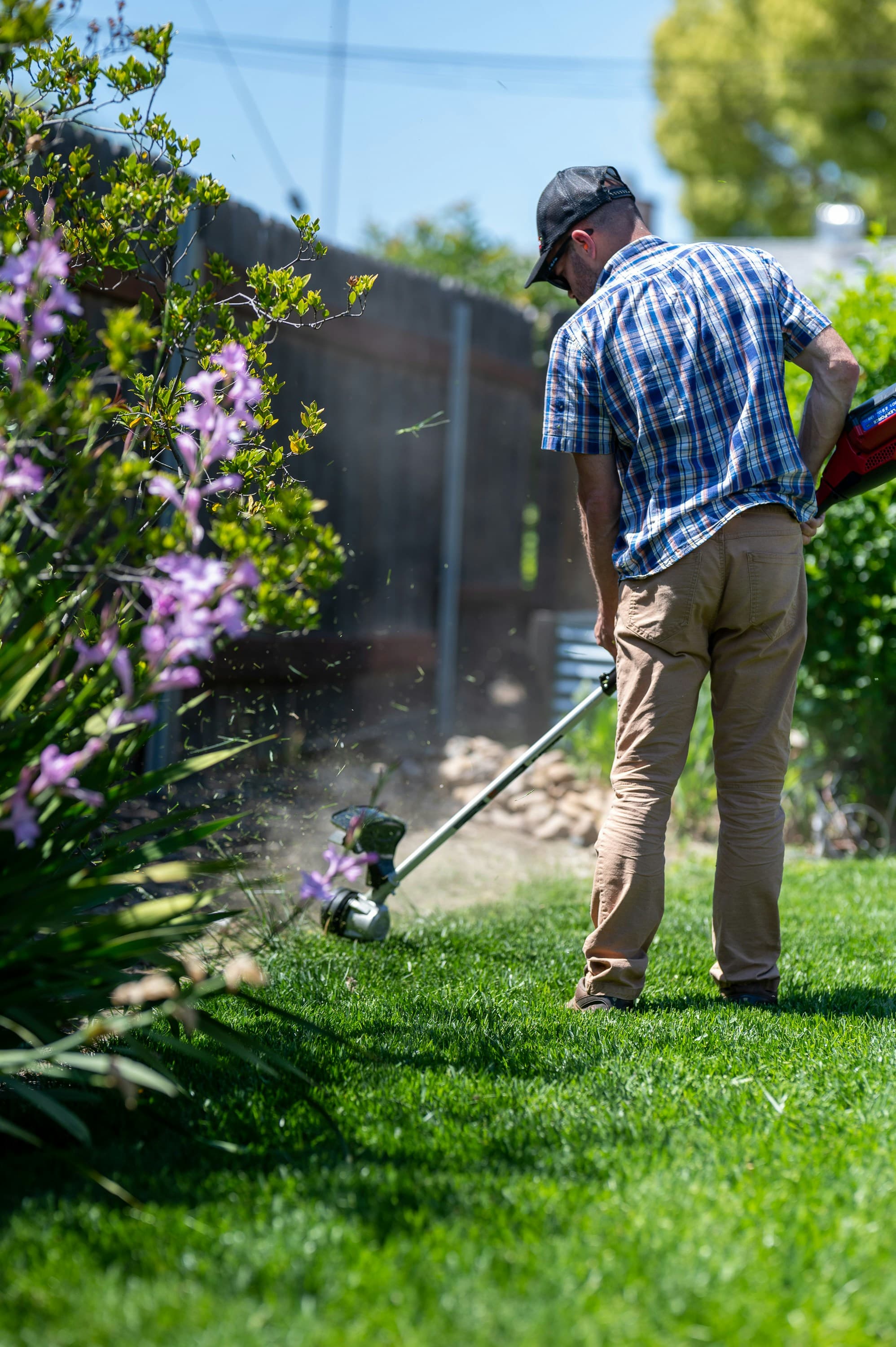 Landscaper trimming a residential lawn on a drive-time optimized route booked through Driive scheduling